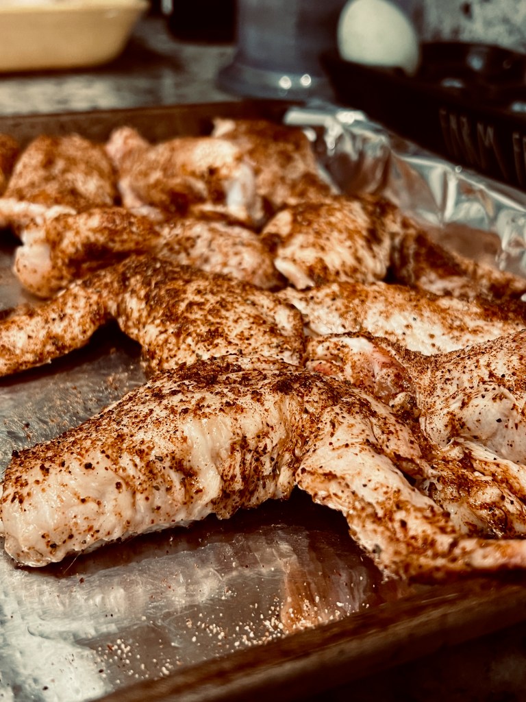 A sheet pan of dry-rubbed chicken wings. 